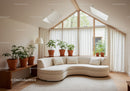 Bright modern living room with curved sofa and plants