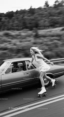 Young woman roller skating beside classic car on road