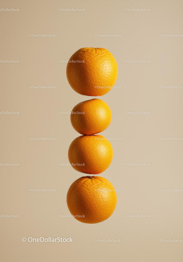 Four ripe oranges stacked vertically on beige background
