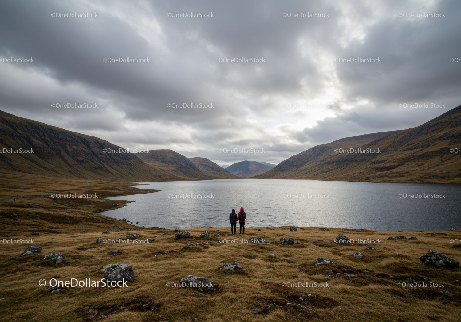 Scenic Mountain Valley Lake with Hikers Under Cloudy Sky