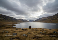 Scenic Mountain Valley Lake with Hikers Under Cloudy Sky