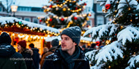Man enjoying festive winter market with holiday lights