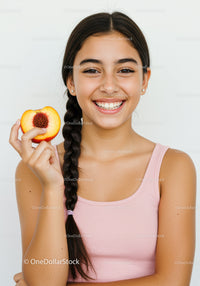 Smiling Young Girl Holding Fresh Peach in Bright Studio Setting
