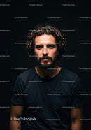 Thoughtful man with curly hair in dark t-shirt portrait