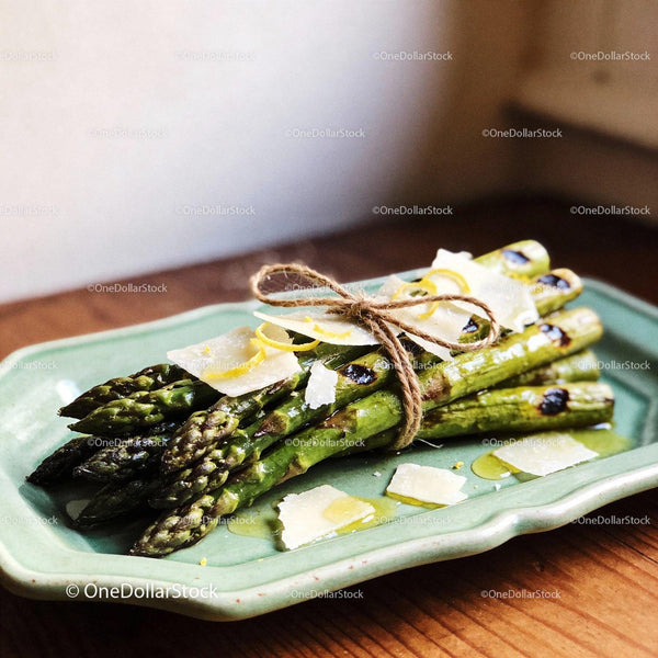 Grilled asparagus tied with twine and parmesan slices