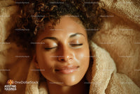 Relaxed Woman Sleeping Surrounded by Warm Towels and Soft Lighting
