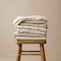Stack of Soft Beige Baby Blankets on Wooden Stool