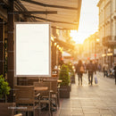 Empty outdoor cafe seating and blank street sign at sunset