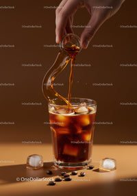 Hand Pouring Cold Brew Coffee Over Ice Cubes