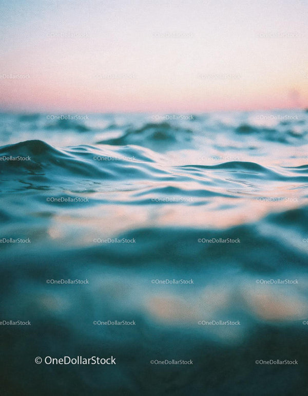 Spokojne fale oceanu o zachodzie słońca z pastelowym niebem