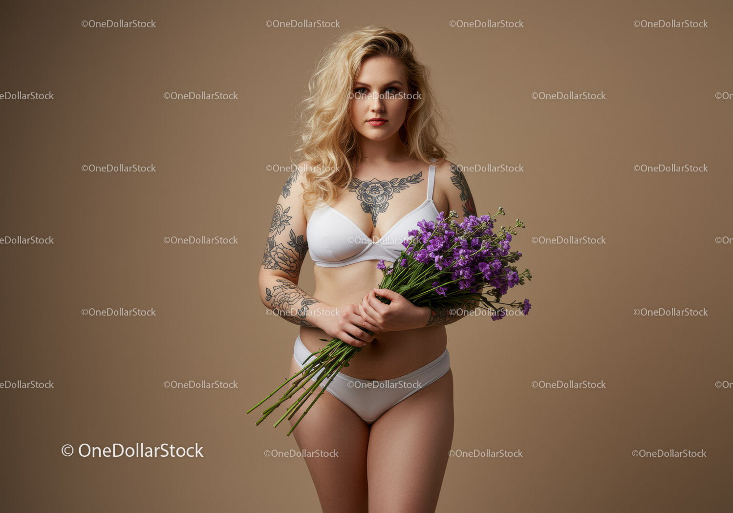 Beautiful Tattooed Woman Holding Purple Flowers in Stylish Studio Shot