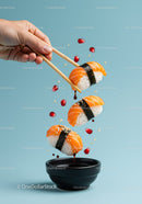 Fresh salmon sushi dipping in soy sauce with chopsticks
