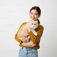 Smiling woman holding a fluffy cream cat