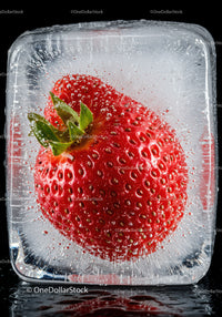 Fresh strawberry perfectly frozen inside ice cube