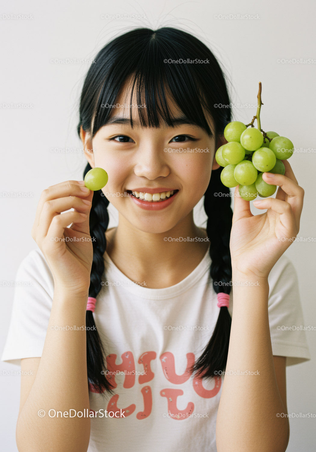 Smiling Young Girl Holding Fresh Green Grapes for Healthy Lifestyle