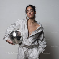 Stylish Woman in Metallic Outfit Holding Disco Ball for Modern Fashion