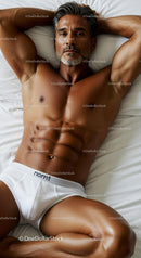 Fit mature man relaxing on bed in white underwear