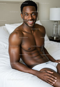 Smiling muscular man relaxing on bed in bright room