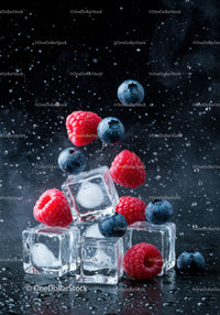 Fresh raspberries and blueberries with ice cubes splash