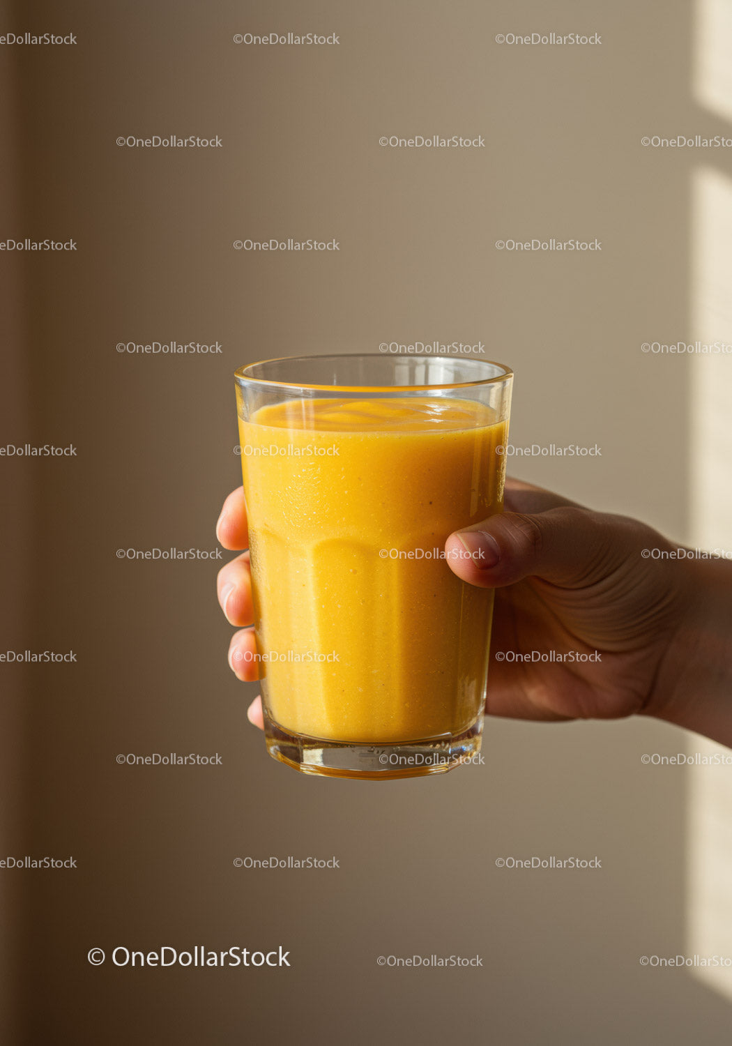 Hand Holding Glass of Fresh Mango Smoothie