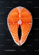 Fresh raw salmon steak on black textured surface