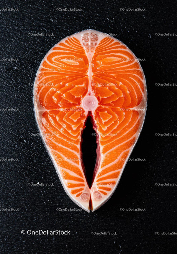 Fresh raw salmon steak on black textured surface
