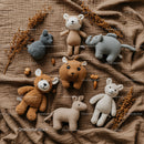 Soft animal plush toys arranged on warm fabric background