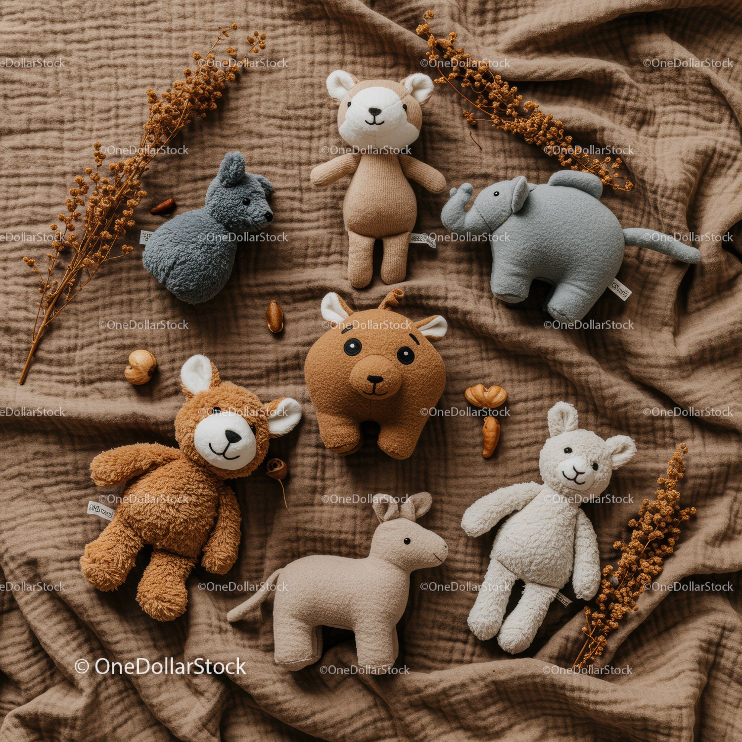Soft animal plush toys arranged on warm fabric background