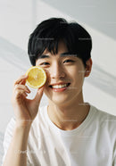 Young Man Smiling with Lemon Slice Showing Bright Happy Face
