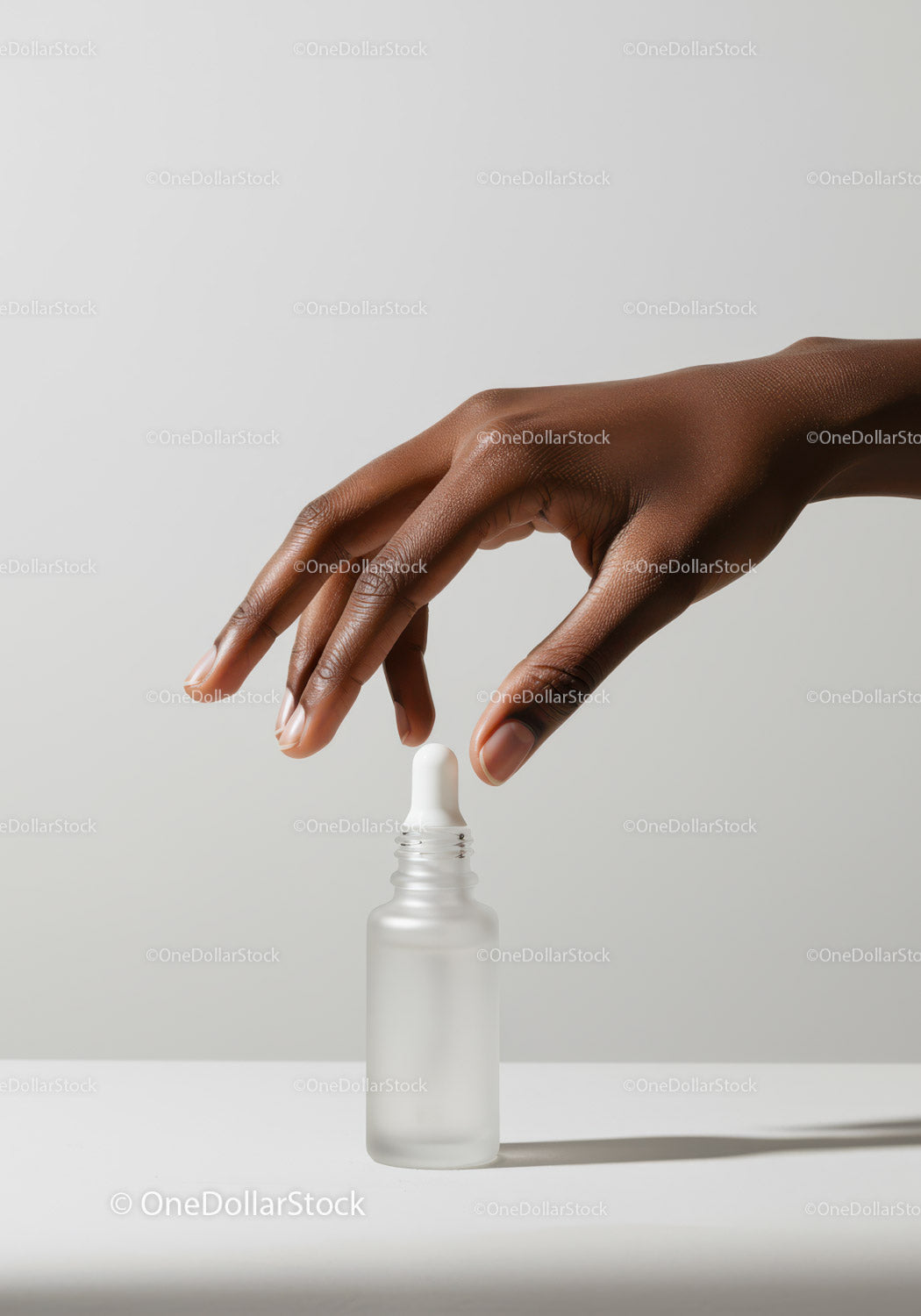 Elegancka ręka z kroplomierzem i butelką z serum do pielęgnacji skóry