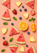 Assorted fresh summer fruit slices on soft pink background