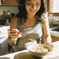 Pregnant woman enjoying breakfast cereal at home kitchen