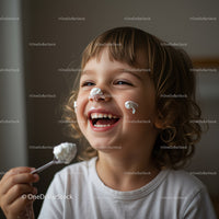 Happy child enjoying a spoonful of creamy dessert