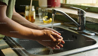 Person Washing Hands Under Running Kitchen Faucet