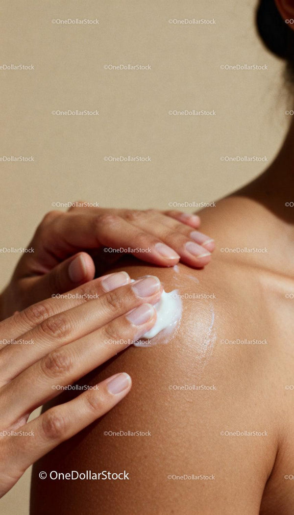 Close up of woman applying body lotion on shoulder