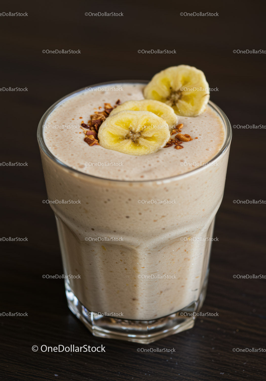 Creamy banana smoothie topped with granola in glass