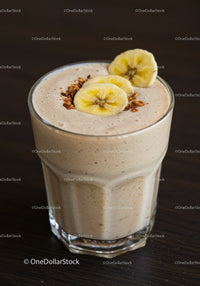 Creamy banana smoothie topped with granola in glass