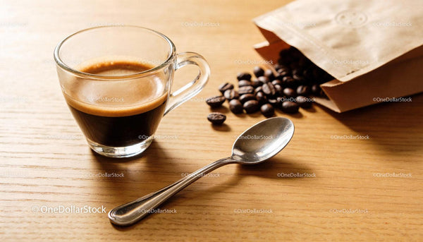 Freshly brewed espresso with coffee beans and spoon