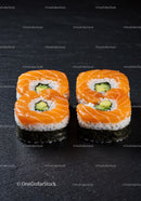 Fresh salmon sushi rolls with avocado on black slate