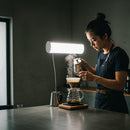 Barista brewing pour over coffee in minimalist cafe
