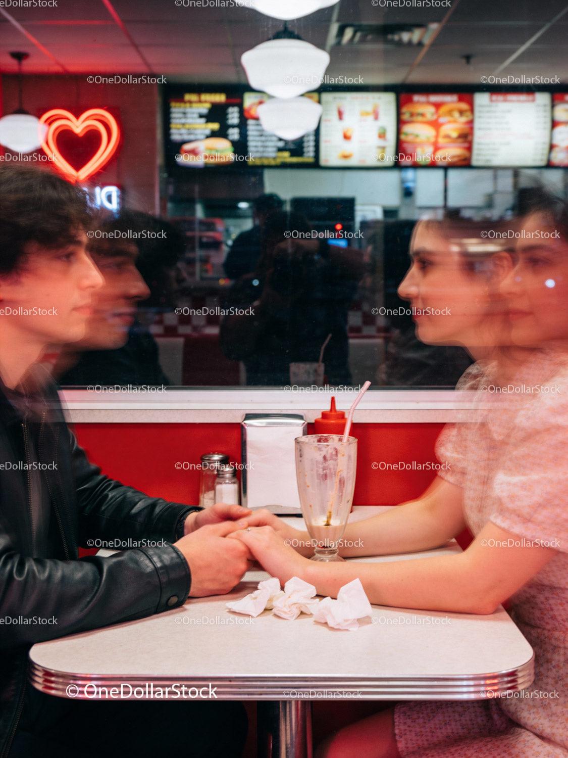 Couple Holding Hands at Retro Diner with Neon Heart