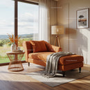 Cozy orange chaise lounge by window with countryside view