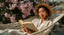 Relaxing Woman Reading Book in Hammock Amid Pink Flowers