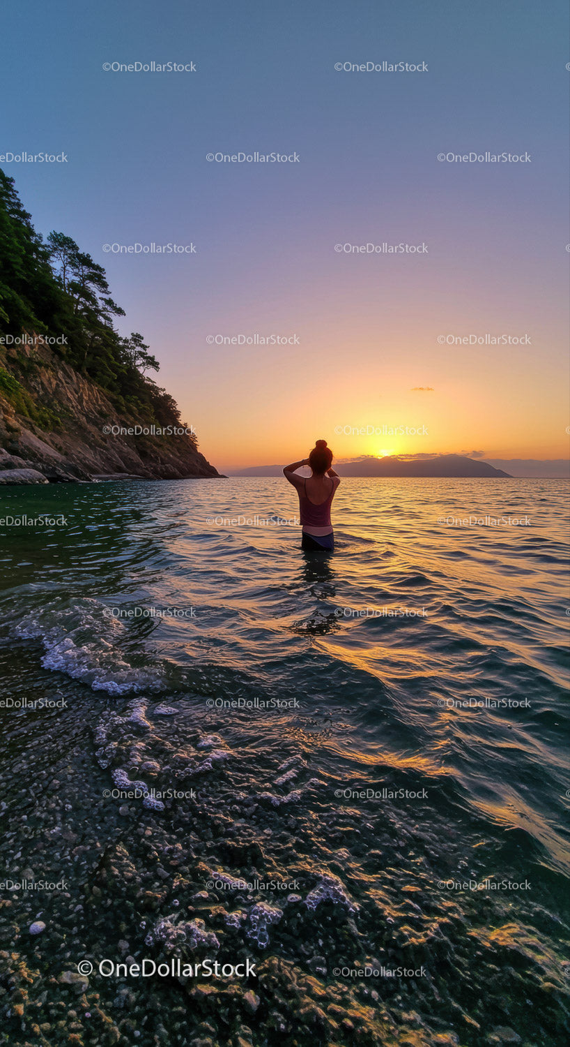 Serene Woman Swimming at Sunset Over Rocky Coastline in Nature