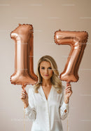 Young woman celebrating seventeenth birthday with balloons