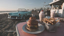 Cheeseburger with French Fries and Milkshakes by Classic Car on Beach