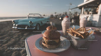 Cheeseburger with French Fries and Milkshakes by Classic Car on Beach