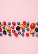 Fresh Mixed Berries with Mint Leaves on Pink Background