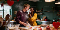 Couple playfully baking heart-shaped cookies together