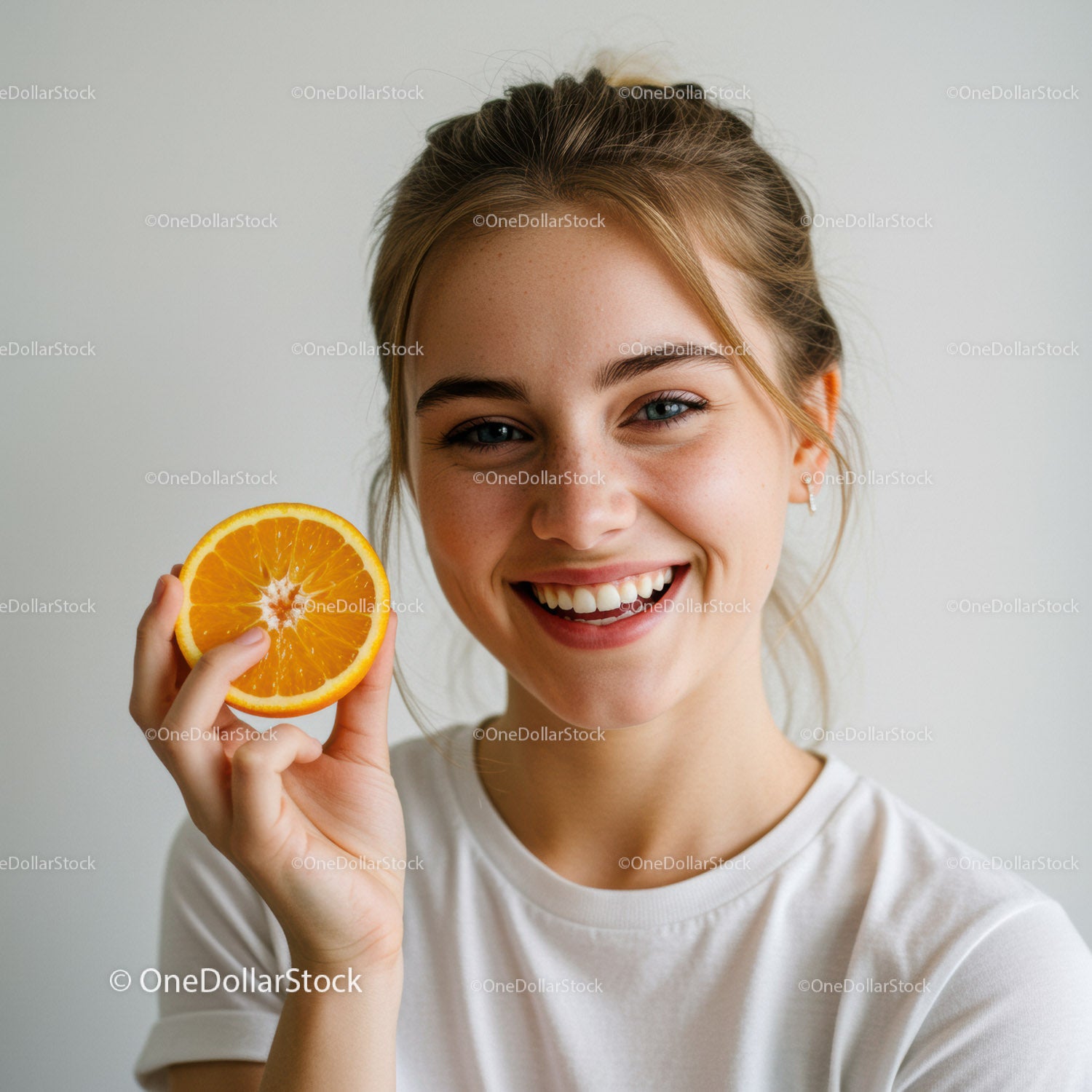 Bright Smiling Girl Holding Fresh Orange Slice for Healthy Lifestyle